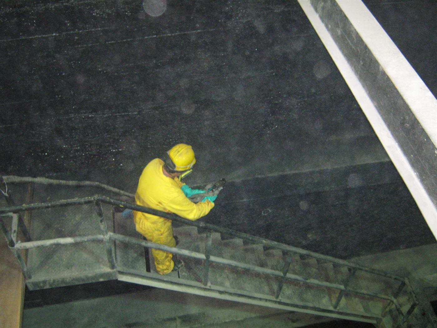 Operario inspeccionando el interior de un tanque de almacenamiento